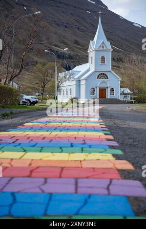 Church with Rainbow Road at Seydisfjordur, Iceland, view from low angle, vertical shot Stock Photo