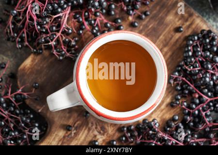A white ceramic cup of tea with black elderberry syrup, top view Stock Photo