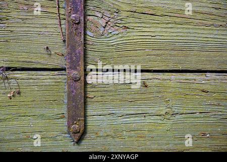 Rusty iron fitting on weathered greenish wood, vintage background texture with large copy space, selected focus Stock Photo