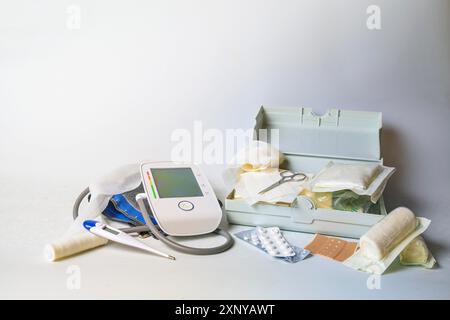 Important medical supplies for first aid and home medicine chest like blood pressure meter, fever thermometer, bandages, plasters and pills, light Stock Photo