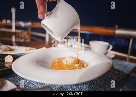 Luxurious Waterfront Dining Experience with Creamy Soup at Night Stock Photo
