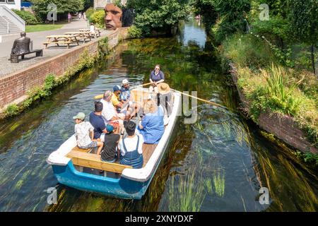 River Trip,Tour,River Stour,Canterbury,Kent,England Boat passing the Marloew Theatre and the seated statue of Canterbury comedian, Dave Lee. Stock Photo