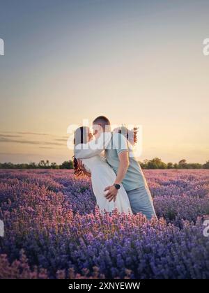 Young couple dancing together in a lavender field. Picturesque summer scenery. Love and romance marriage conceptual portrait Stock Photo