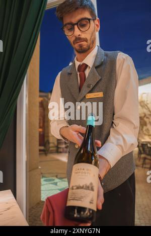 Waiter Presenting Casa de Impost Wine in Luxury Hotel Dining Area Stock Photo
