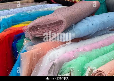Vibrant fabric bolts are displayed in an outdoor market in the Netherlands. Stock Photo