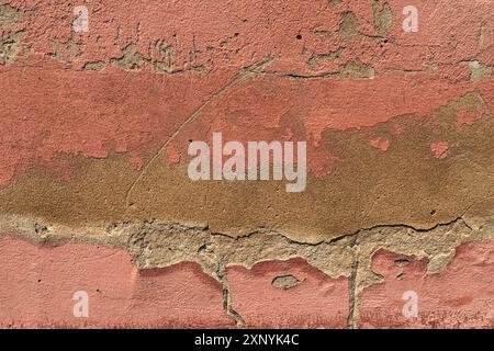 Chipped paint on a weathered European stone wall creates an interesting background plate Stock Photo