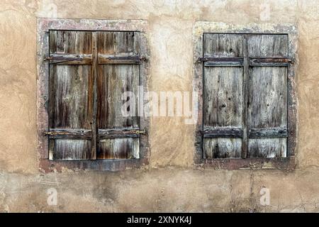 Two weathered, wooden window shutters side by side on a wall, create an interesting European still life scene. Stock Photo