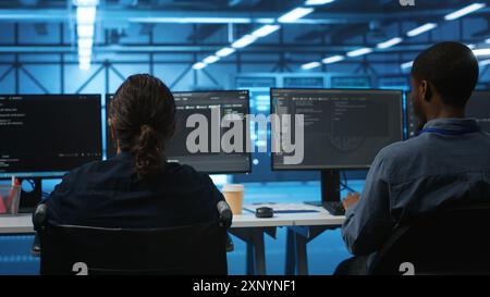 Person with paraplegia working in inclusive workplace typing data on PC, doing needed adjustments in supercomputers server hub housing advanced data storage infrastructure Stock Photo