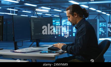 System administrator in server room doing system analysis, coding, doing needed adjustments for supercomputers to run. Specialist working in high tech facility housing advanced storage infrastructure Stock Photo