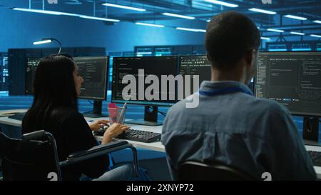 Person with paraplegia typing data on PC, doing needed adjustments in supercomputers server farm housing advanced data storage gear supporting critical IT workloads, close up Stock Photo