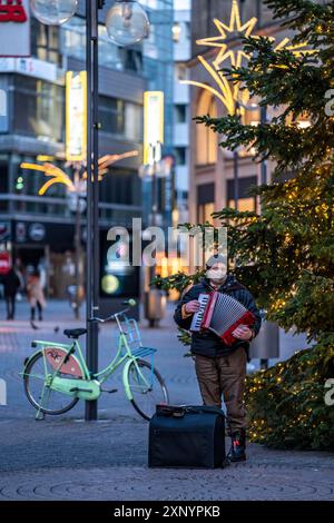 First day of the Christmas lockdown in the Corona crisis, empty shopping alleyway Schildergasse, lonely alleyway musician in front of a Christmas Stock Photo