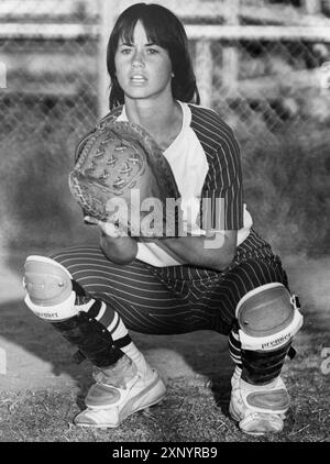 College Station Texas USA, 1977: Female college student playing catcher crouches behind the plate during Texas A&M University women's softball team practice. ©Bob Daemmrich Stock Photo