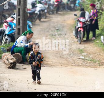 Little boy from the Hmong minority in badman jacket walking on a slope, Bac Sum village, Ha Giang province, Vietnam Stock Photo