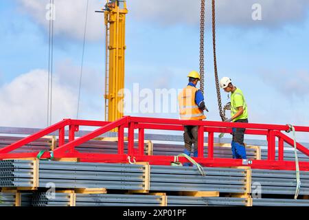 Construction workers assembling a high-bay warehouse in an industrial estate in Magdeburg Stock Photo