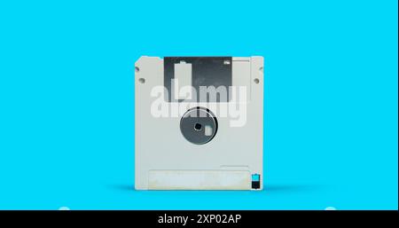 Front view of old white plastic square computer floppy disk on a blue surface against blue background Stock Photo