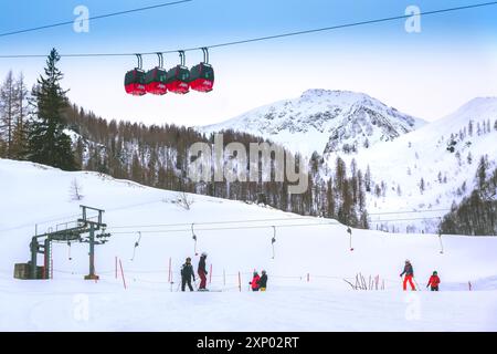 Saalbach-Hinterglemm, Austria, March, 5, 2020: Ski slope, four red cable car cabins, skiers and snowboarders Stock Photo