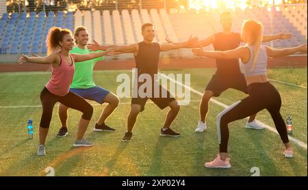 Group of sporty young people training in the stadium Stock Photo