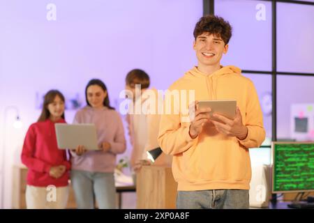 Male programmer with tablet computer in office at night Stock Photo