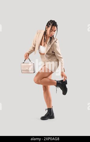 Stylish African-American woman with dreadlocks on light background Stock Photo