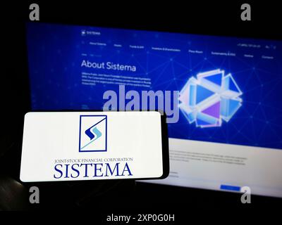 Stuttgart, Germany, 03-05-2022: Person holding cellphone with logo of Russian conglomerate AFK Sistema PAO on screen in front of company webpage. Stock Photo