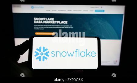 Stuttgart, Germany, 03-05-2022: Person holding smartphone with logo of US software company Snowflake Inc. on screen in front of website. Focus on Stock Photo