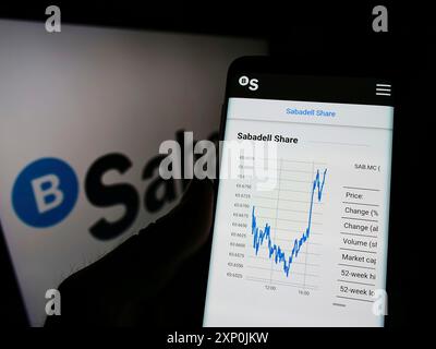 Stuttgart, Germany, 01-29-2022: Person holding cellphone with website of Spanish banking company Banco de Sabadell SA on screen with logo. Focus on Stock Photo