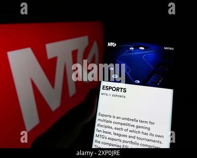 Stuttgart, Germany, 01-29-2022: Person holding cellphone with webpage of Swedish company Modern Times Group AB (MTG) on screen in front of logo. Stock Photo