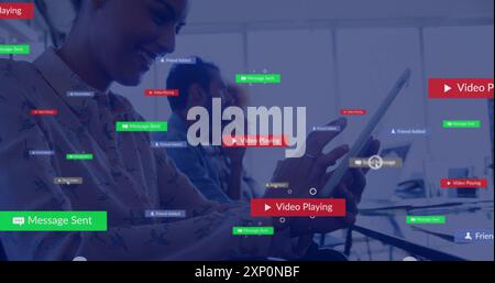 Image of social media notifications over happy caucasian businesswoman using tablet at work Stock Photo