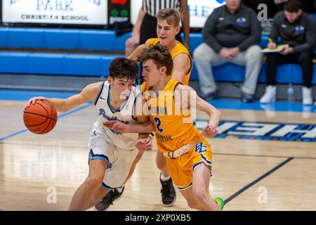 A Blackhawk Christian player leans into a Lakewood Park player during an IHSAA boys high school basketball game at Lakewood near Auburn, Indiana, USA. Stock Photo