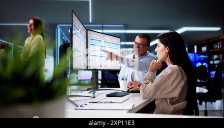 People Working With Spreadsheet Data On Computer Monitor Stock Photo