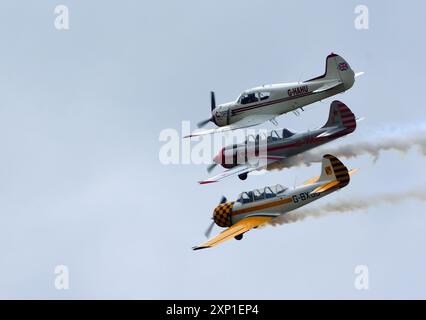 Vintage Yakovlev Yak 18T ,Yak 50 and 52 in  close formation flight against blue sky. Stock Photo