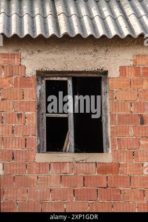old brick building with a tin roof, dereliction, derelict building ith metal or tin roof. Stock Photo