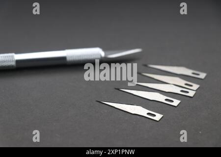 Hobby knife also called as crafting knife with spare blades isolated on black background Stock Photo