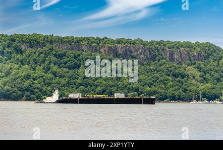 large tug boat pushing a large barge up the hudson river Stock Photo