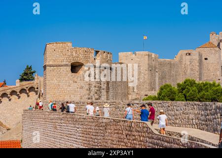 DUBROVNIK, CROATIA - JUNE 29, 2024: Tourists walk around spectacular ancient city walls which encircle Dubrovnik's historic Old City Stock Photo