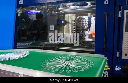 Close-up of plastic spoon product on plastic injection molding press machine Stock Photo