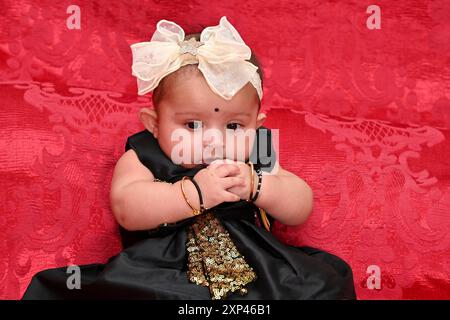 Cute little baby girl wear colorful dress with hair band  she playing  and happy for her activities in the rice ceremony occasion. Stock Photo