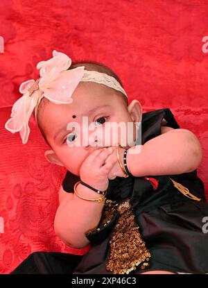 Cute little baby girl wear colorful dress with hair band  she playing  and happy for her activities in the rice ceremony occasion. Stock Photo