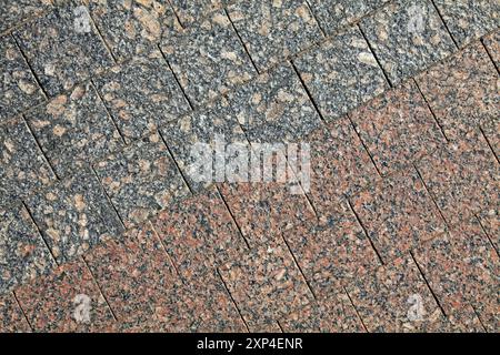 Paving slabs of square shape, texture, background. Paving slabs of grey and red granite blocks of regular shape, close-up. Two-tone smooth pavement Stock Photo