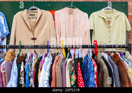 Secondhand clothes for sale in an outdoor market, UK. 2024 Stock Photo