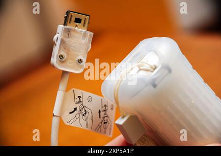 USB Cable Close-Up with Connectors on Orange Background Stock Photo