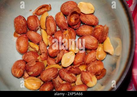Close-up of roasted peanuts in a bowl, showcasing their texture and color Stock Photo