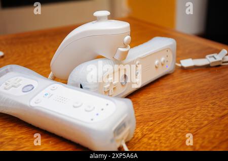 White Gaming Controllers on Wooden Table Ready for Fun Stock Photo