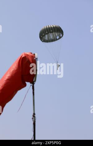 A parachutist prepares to land on Glen Rock Dropzone, Exeter, Rhode Island during Leapfest 2024. Leapfest is the largest, longest standing, international static line parachute training event and competition hosted by the 56th Troop Command, Rhode Island Army National Guard to promote high level technical training and esprit de corps within the International Airborne community. (U.S. Army Reserve photo by Maj. Yau-Liong Tsai) Stock Photo