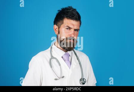 Portrait of serious male doctor or physician in white medical coat with stethoscope in hospital. Treatment, healthcare, medicine and ambulance service Stock Photo