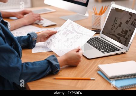 Cartographer working with cadastral map at wooden table, closeup Stock Photo