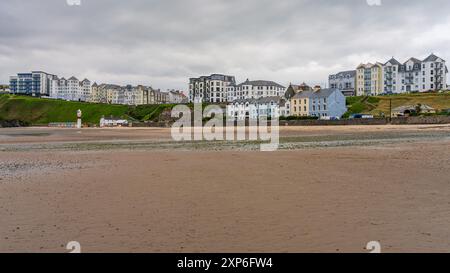 Port Erin, Rushen, Isle of Man - May 18, 2023: Port Erin beach with the beach huts and the lighthouse on the beach Stock Photo