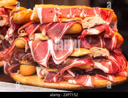 Traditional Spanish bocadillos with Iberico jamon laid out in a slide on a shop window Stock Photo