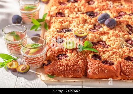 Sweet and delicious plum yeast cake served with lemonade on beach. Plum yeast cake in summer on beach. Stock Photo