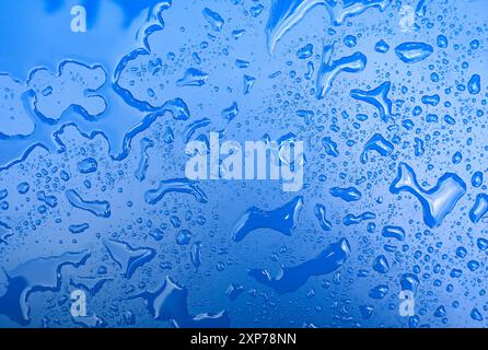 Abstract water shapes after rain on blue surface as texture or background Stock Photo